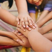 Photo of children putting their hands together